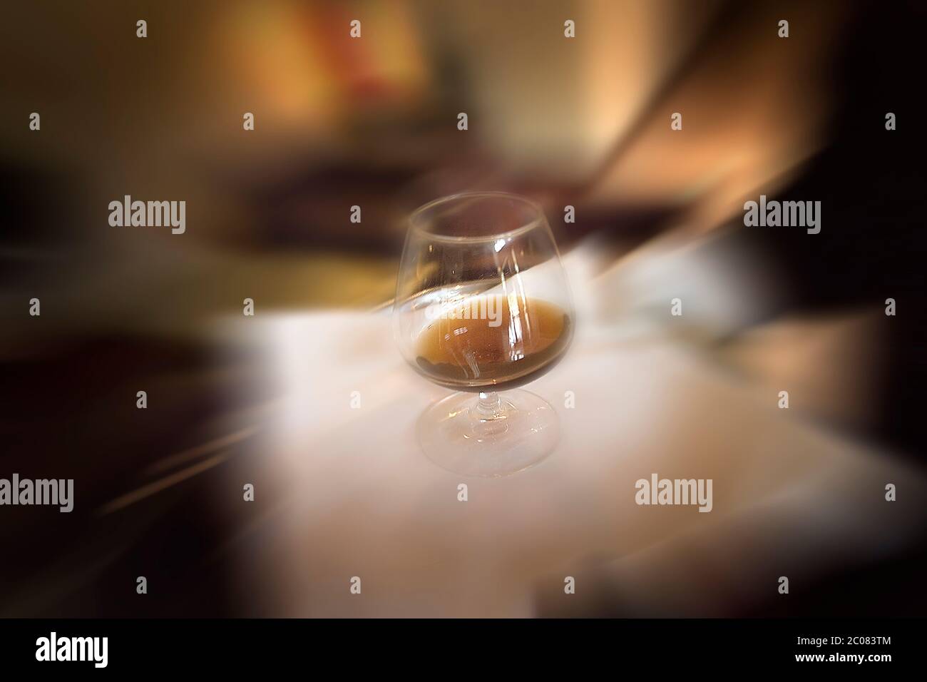 Waiter carrying brandy glass on tray with movement blur Stock Photo