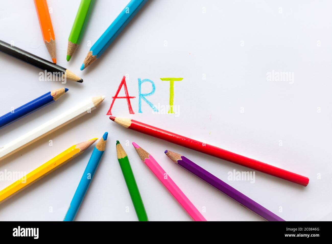 Colorful art pencil layed out on a white paper with the word art ...