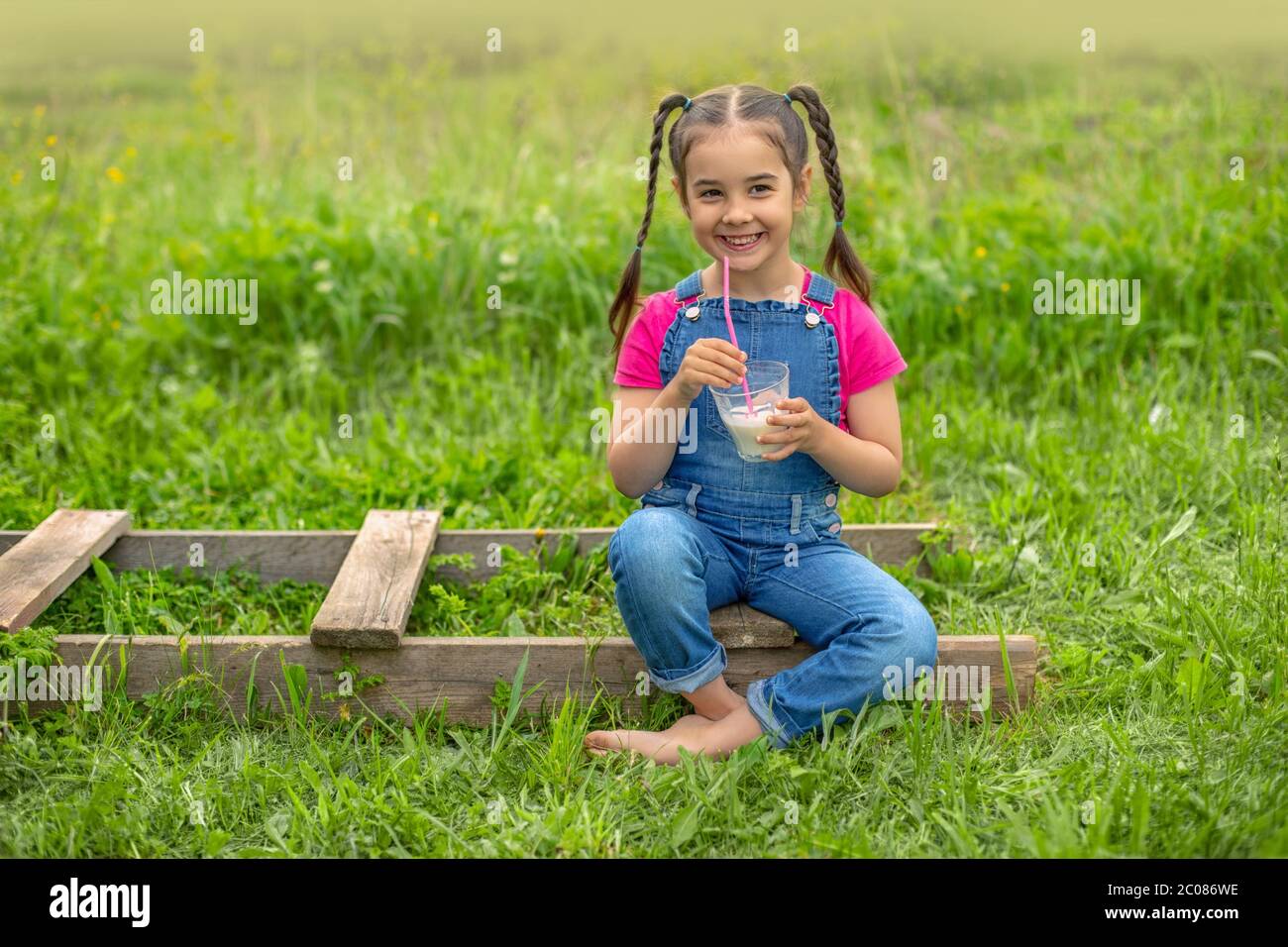 Funny girl in denim overalls and a pink 
