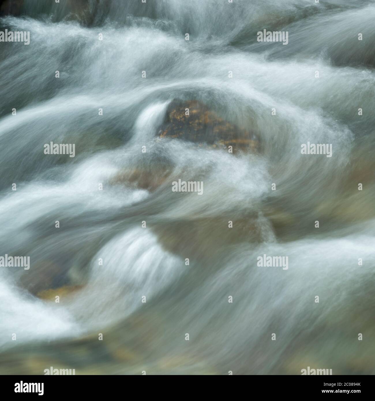 Abstract long exposure of flowing water in a rocky stream, Lake District, Cumbria, England, UK Stock Photo