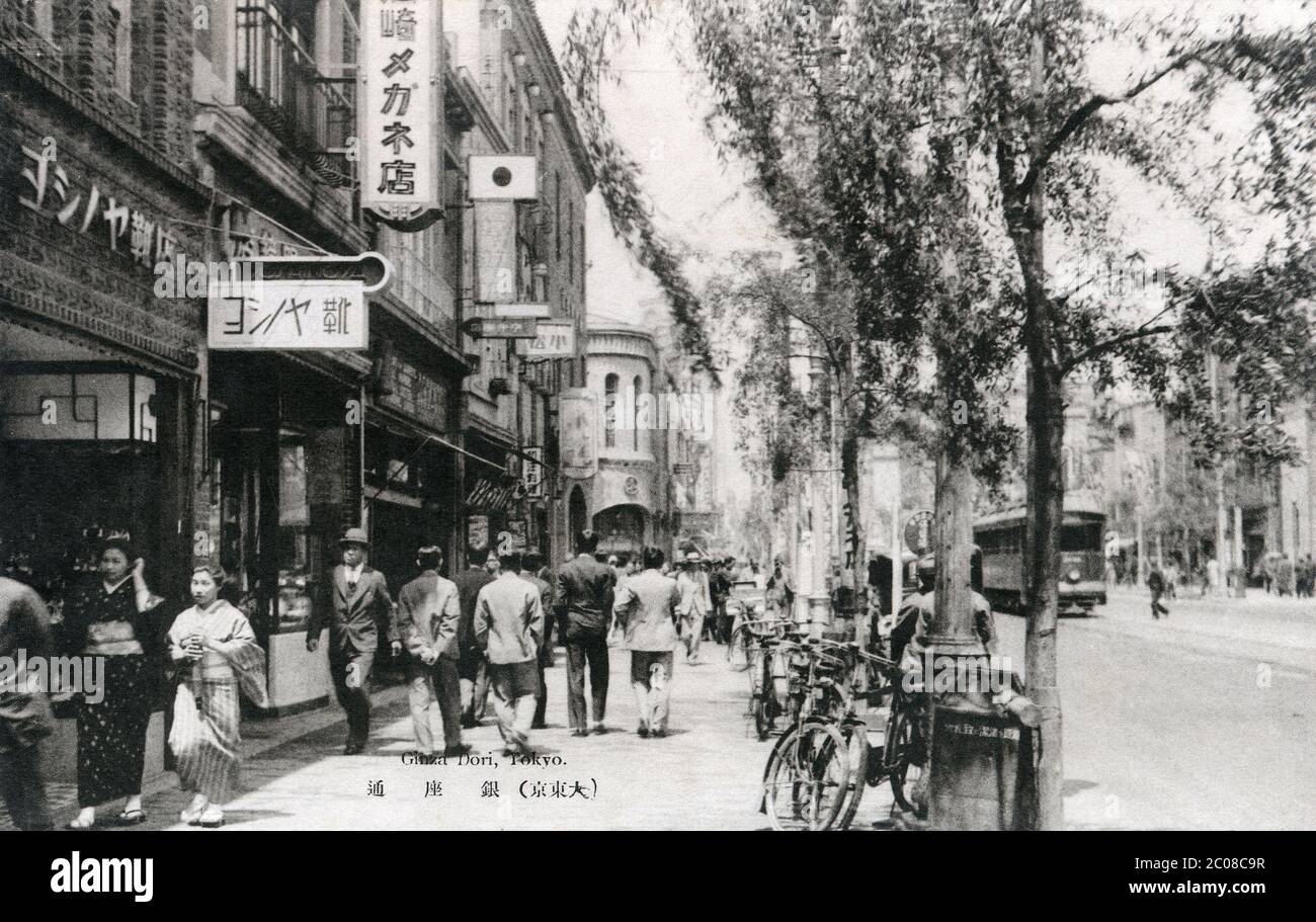 [ 1930s Japan - Tokyo Ginza ] — Pedestrians in front of the famed high-end women's shoe shop Yoshinoya on Ginza Avenue in Tokyo.  Ginza Yoshinoya (銀座ヨシノヤ) opened in 1907 (Meiji 40) with the motto, “Comfort is Beauty.” The company still exists today.  Japanese text: （大東京）銀座通  20th century vintage postcard. Stock Photo