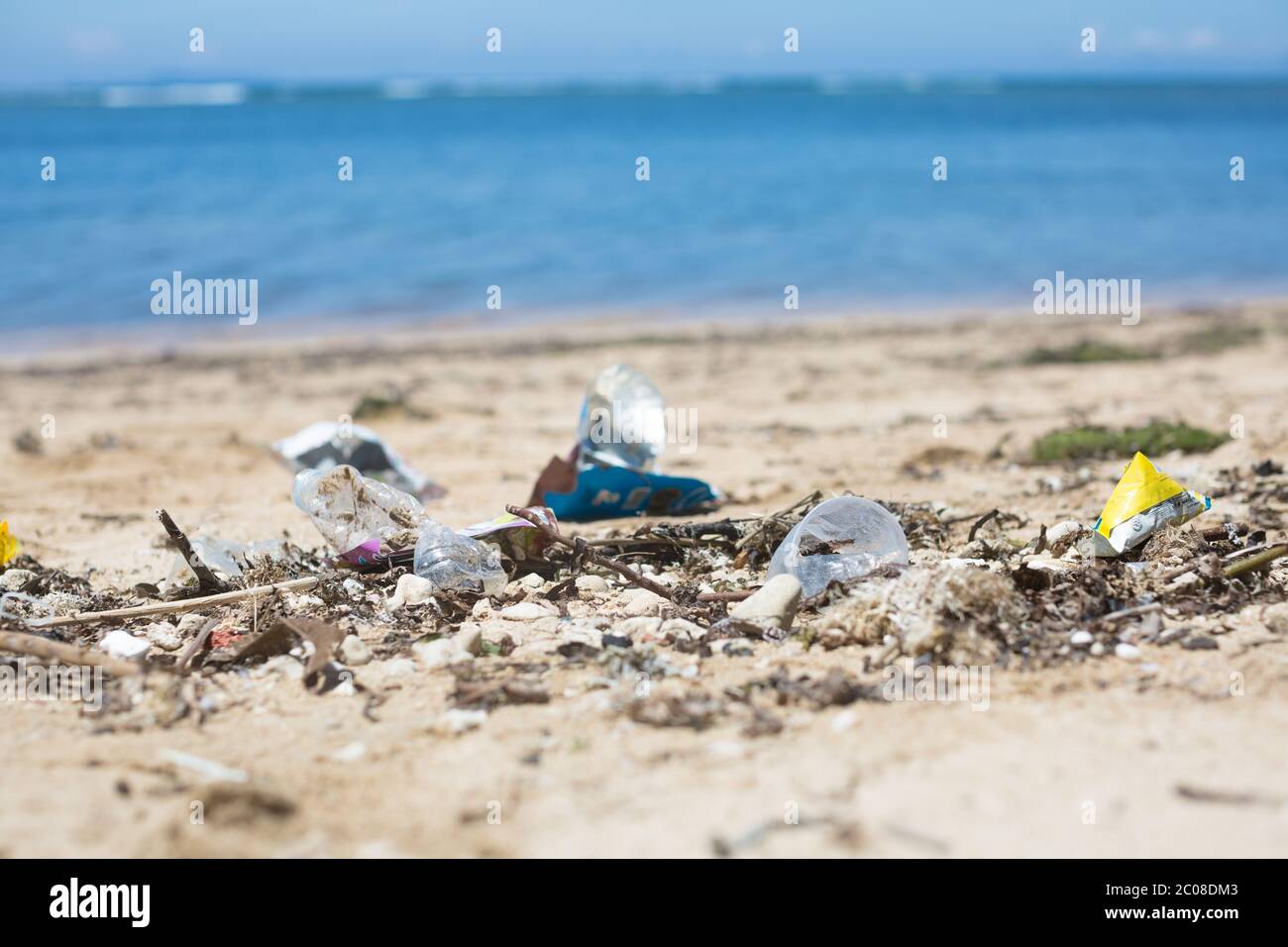 Garbage and litter lying on the sand in Asia with the ocean background. Stock Photo