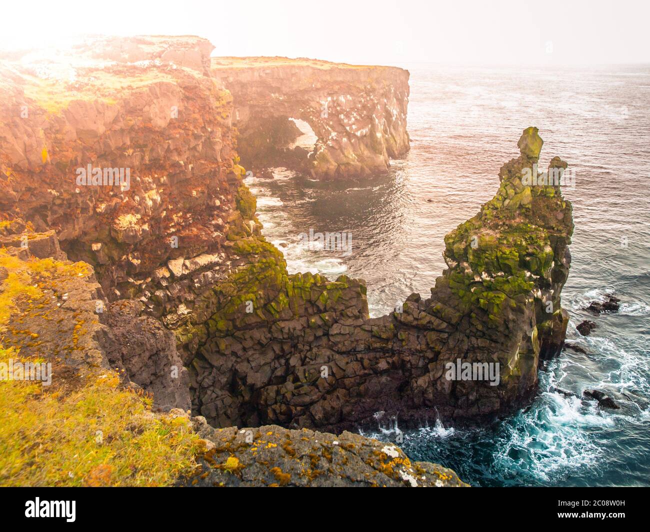 Londrangar, rock lava formation in the sea. Eroded basalt cliffs in the wild sea at coastline on Sneafellsnes peninsula, Iceland. Stock Photo