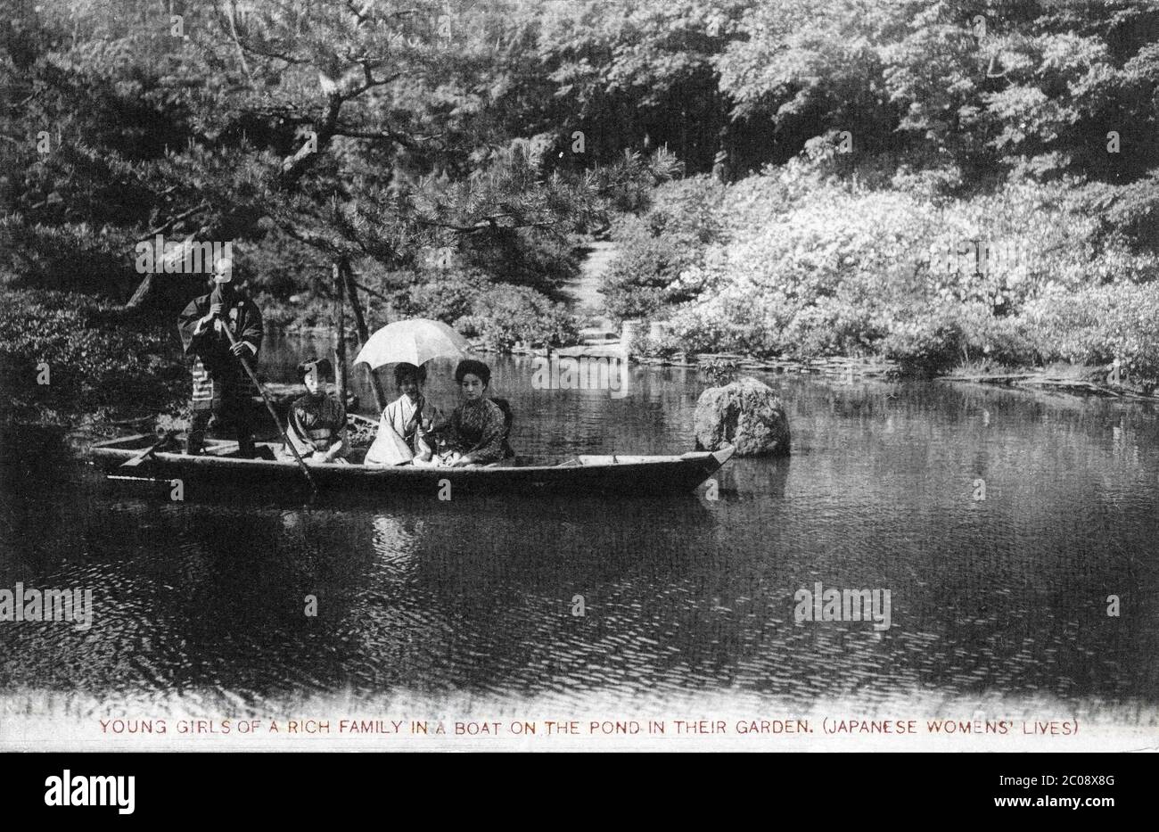 [ 1920s Japan - Women in a Boat ] — Young Japanese women in a boat.  Original text: Young girls of a rich family in a boat on the pond in their garden. (Japanese Women's Lives)  20th century vintage postcard. Stock Photo