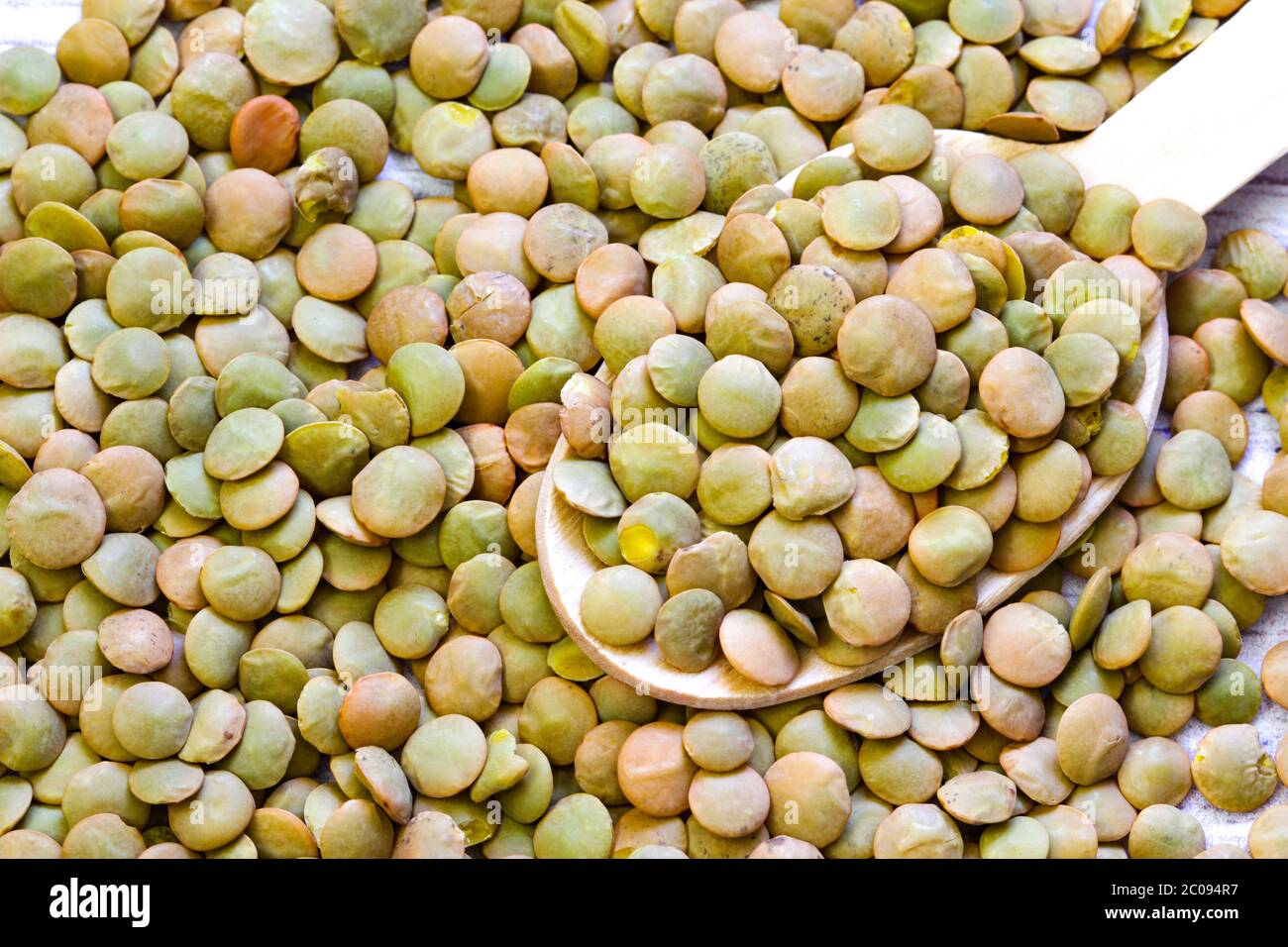 Heap of green lentil texture as background. Uncooked lentils. Top view Stock Photo