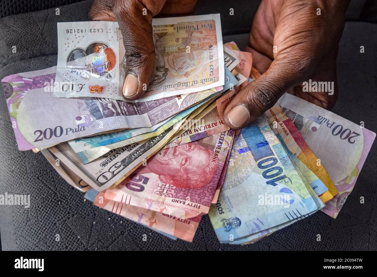 Many Zimbabweans deal daily in a host of currencies from the U.S., Botswana, Great Britain and other countries. Exchange rates are set for those currencies as well as for local mobile money, bond notes and more, but each exchange rate changes from minute to minute on the black market. (Linda Mujuru, GPJ Zimbabwe) Stock Photo