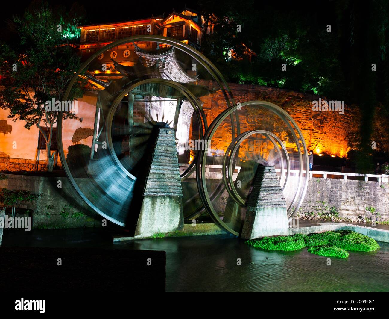 Vintage watermill wheel in Lijiang Old Town by night, Yunnan, China Stock Photo