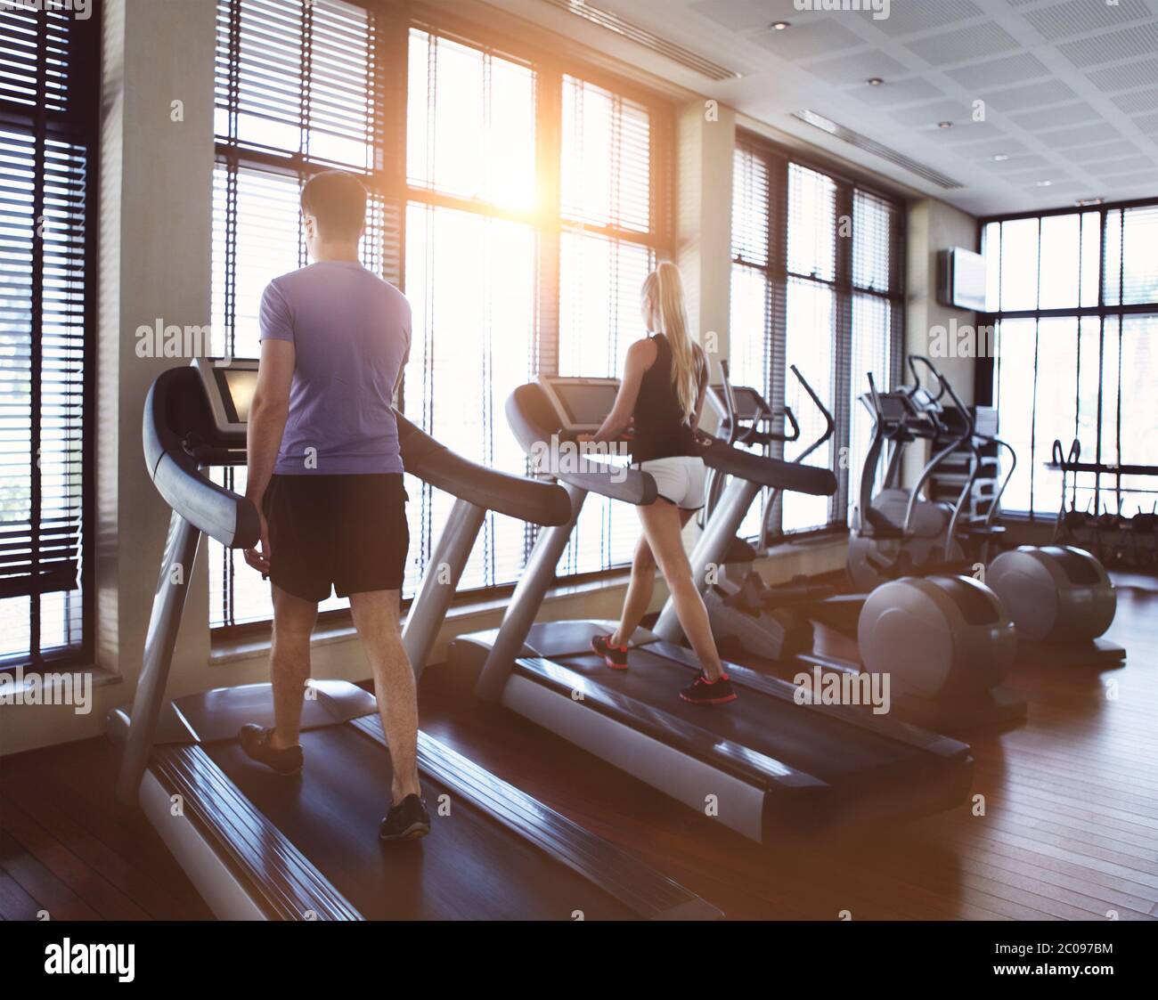 Healthy man and woman running on a treadmill in a gym Stock Photo - Alamy