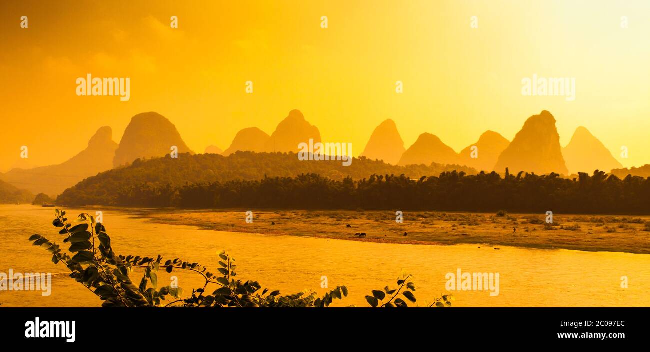 Sunset panorama in karst landscape around Yangshuo an Li River with peaks silhouettes, Guangxi Province, China. Stock Photo