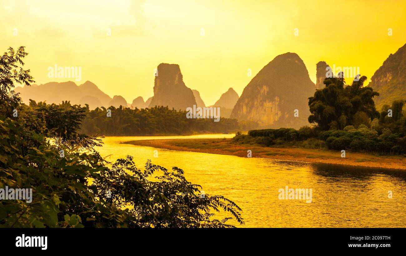 Sunset panorama in karst landscape around Yangshuo an Li River with peaks silhouettes, Guangxi Province, China. Stock Photo