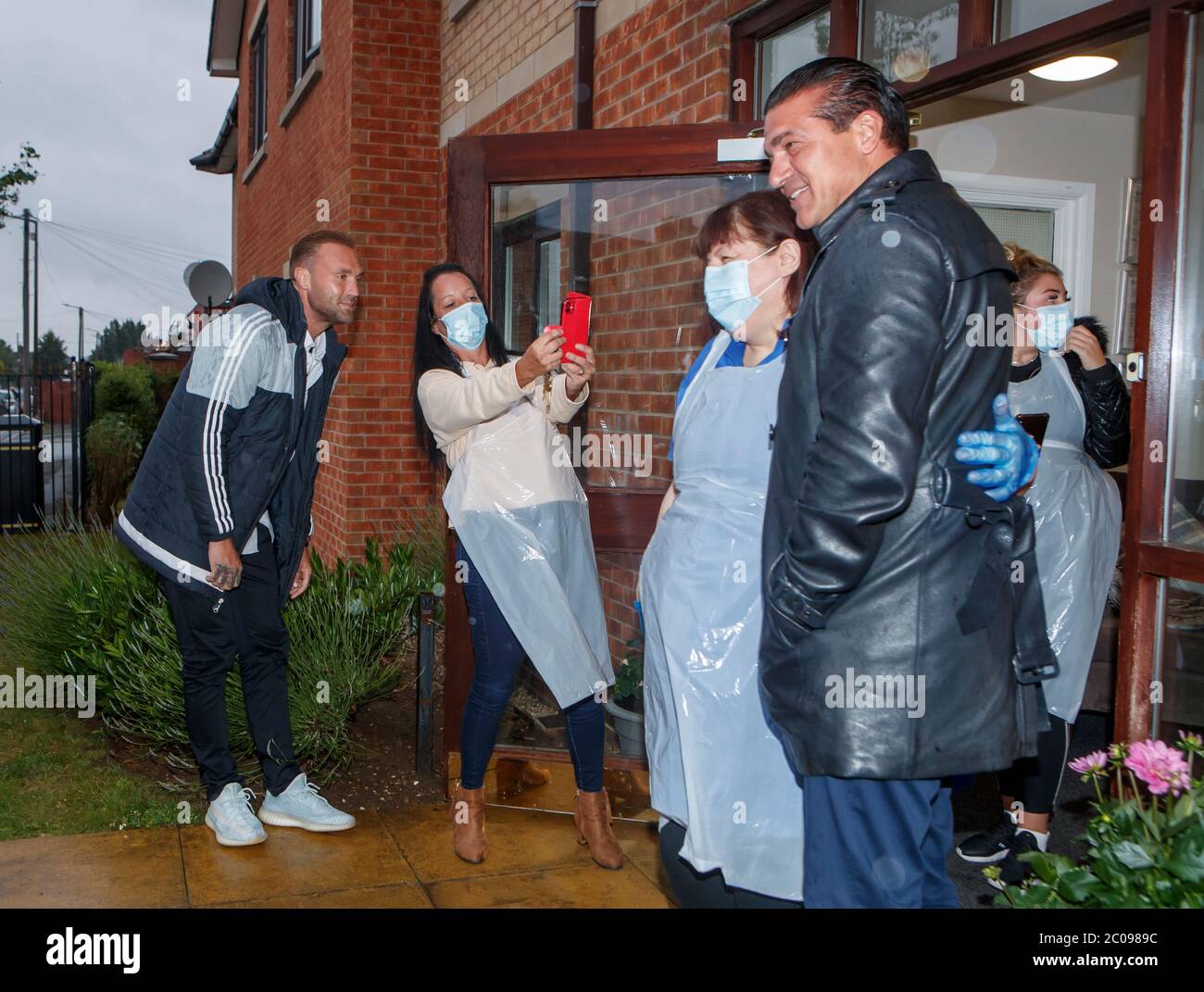 Calum Best (left) and Tamer Hassan (right), with care assistants Maria Lawson (second left) and Pauline Cod (third left), outside the The Royal care home in Rossington, after dropping off a box of Personal Protection Equipment (PPE), that was delivered by plane to Robin Hood Airport in Doncaster, South Yorkshire. ??30,000 worth of PPE has been donated to the Mask Our Heroes charity, which was set up by entrepreneur Matthew McGahan in the wake of the coronavirus outbreak to help supply frontline NHS and health workers with the protective equipment they need. Stock Photo