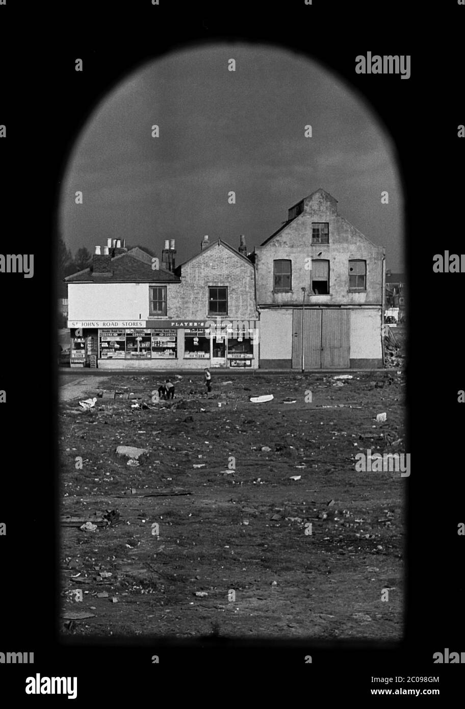 AJAXNETPHOTO. MARCH, 1968. PORTSMOUTH, ENGLAND. - FRAMED - VIEW THROUGH DOORWAY OF PART DEMOLISHED HOUSE OF ST.JOHN'S ROAD STORES, LAKE ROAD AREA. CHILDREN PLAYING ON WASTELAND.PHOTO:JONATHAN EASTLAND/AJAX REF:3568137 10 131 Stock Photo