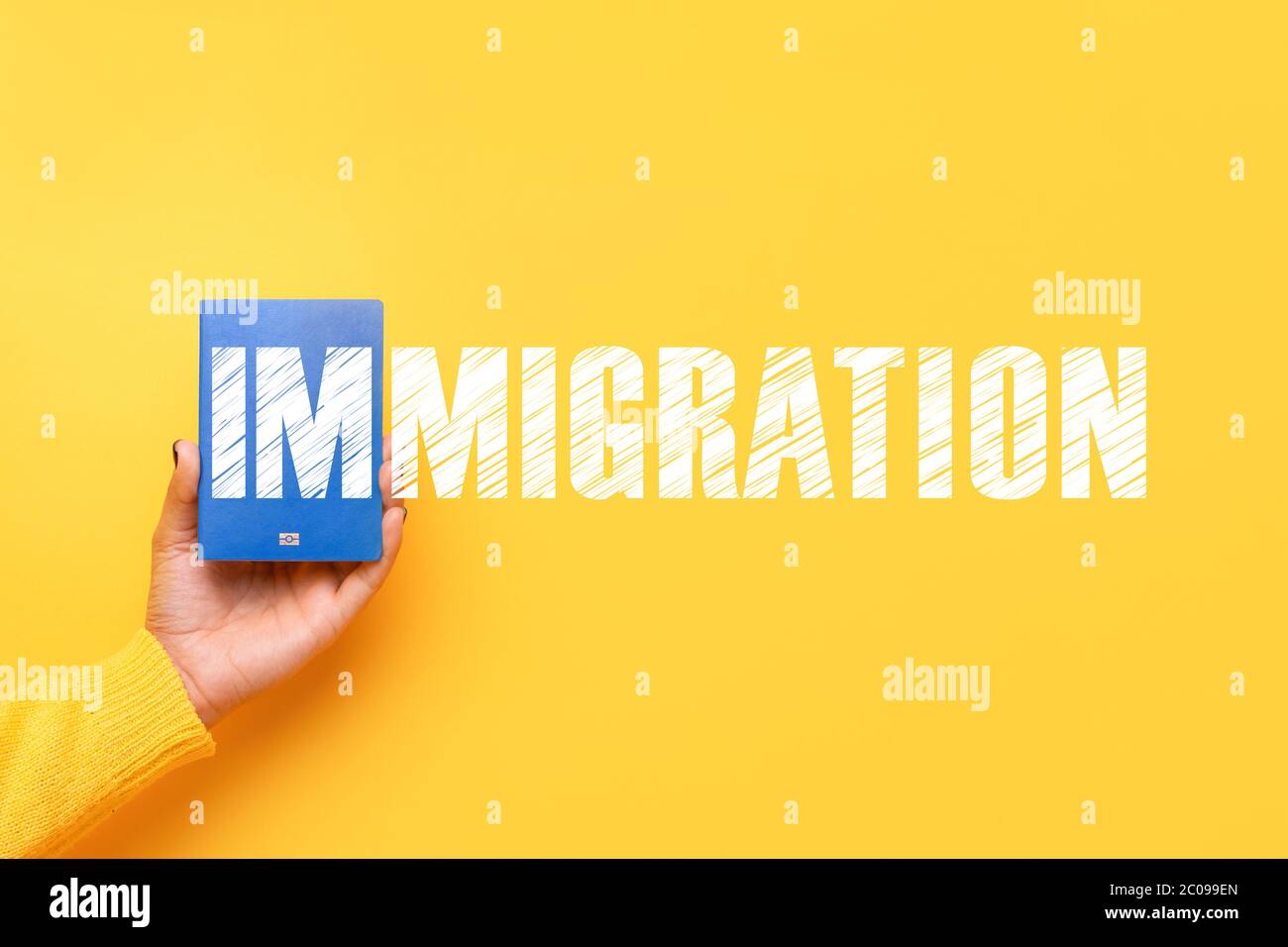 blue passport in hand over yellow background, immigration concept Stock