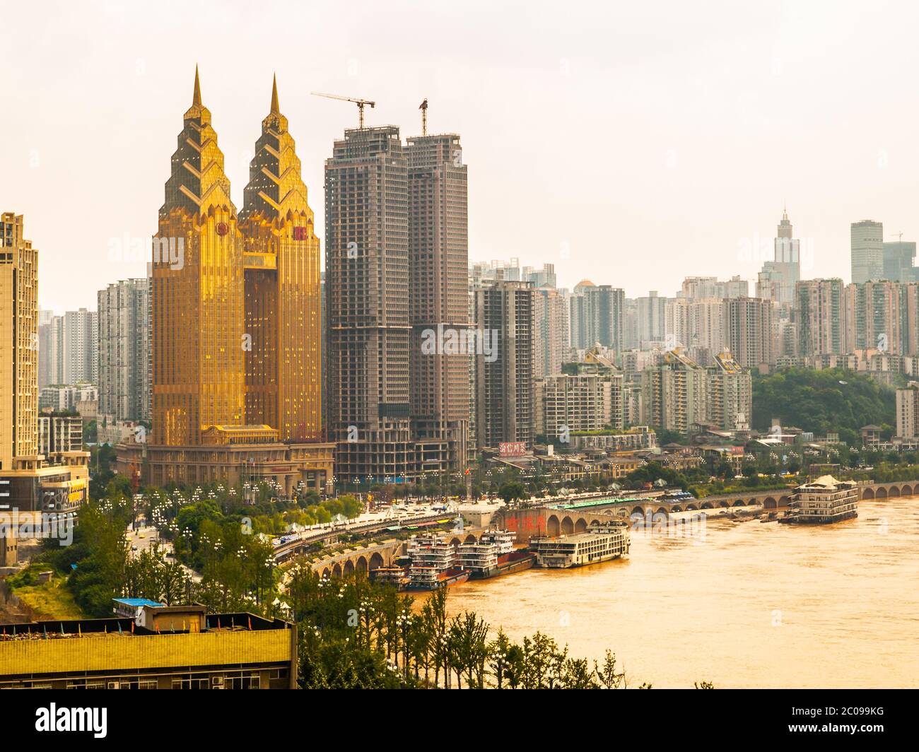 Yangtze riverbank with two golden towers of luxury hotel, Chongqing, China Stock Photo