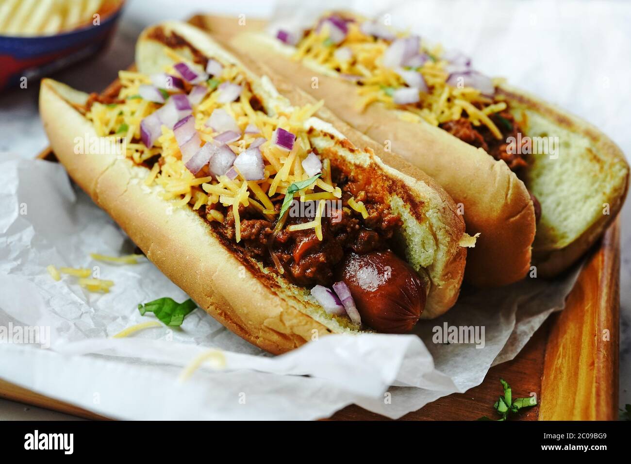 Homemade Chili dogs topped with cheddar cheese, selective focus Stock Photo