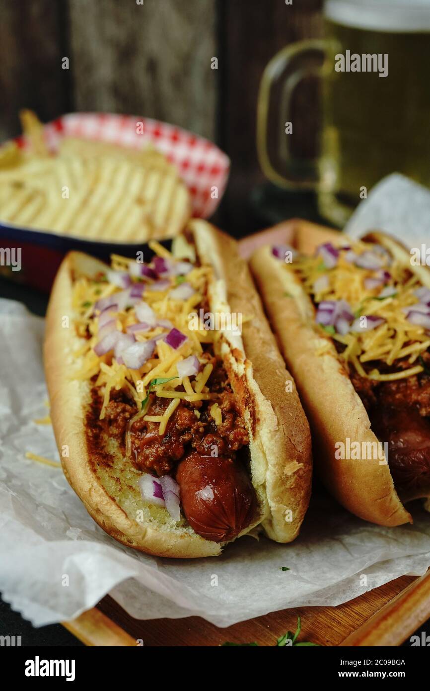 Homemade Chili dogs topped with cheddar cheese, selective focus Stock Photo