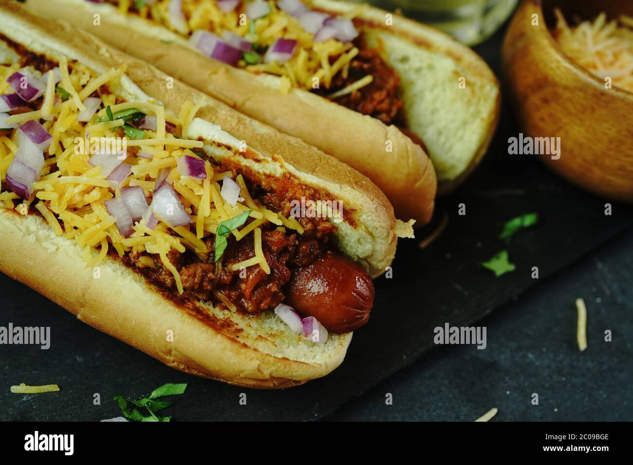 Homemade Chili dogs topped with cheddar cheese, selective focus Stock Photo