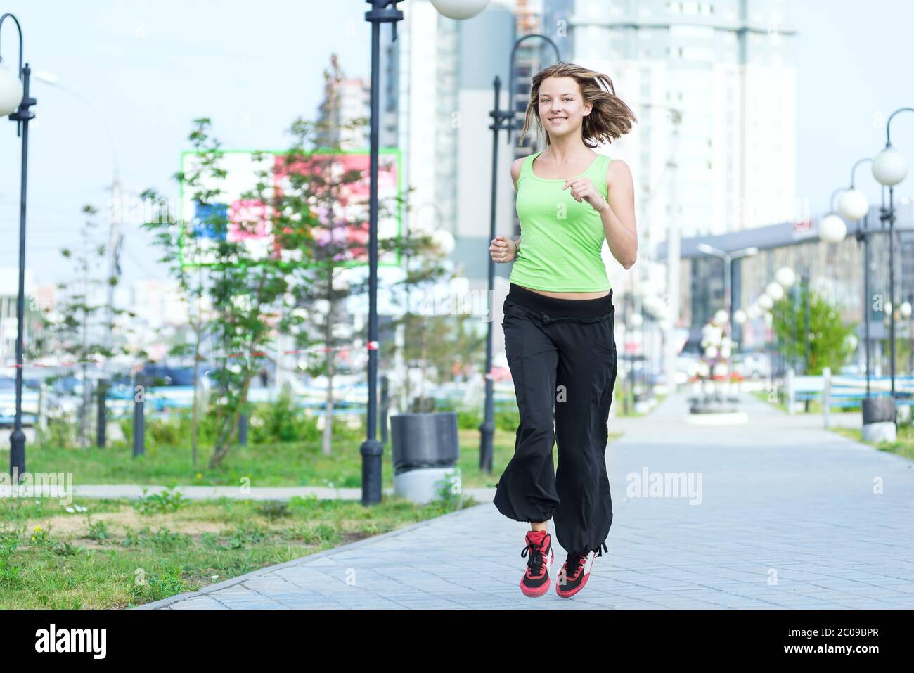 Woman jogging in city street park. Stock Photo