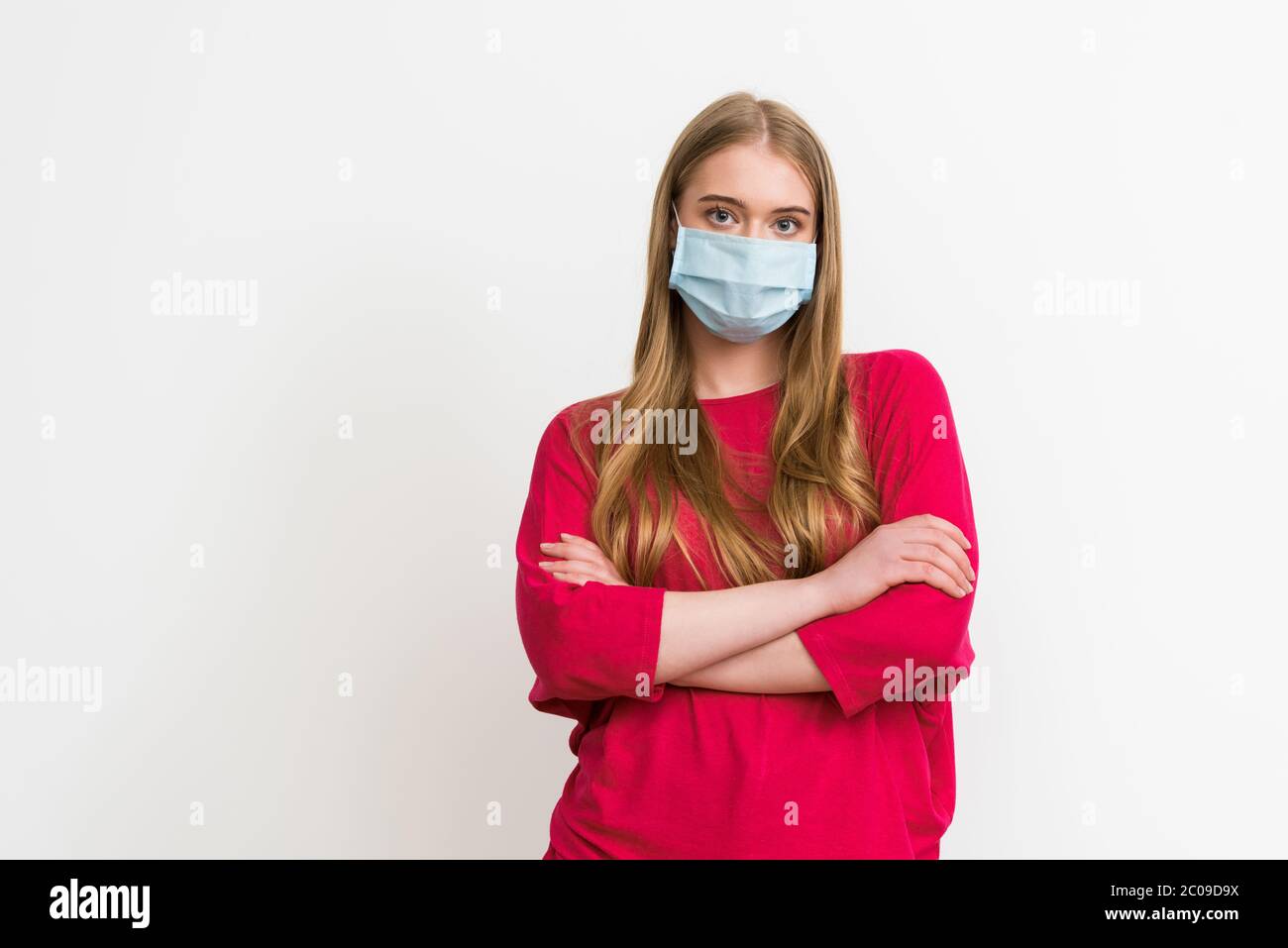 young woman in medical mask standing with crossed arms isolated on ...