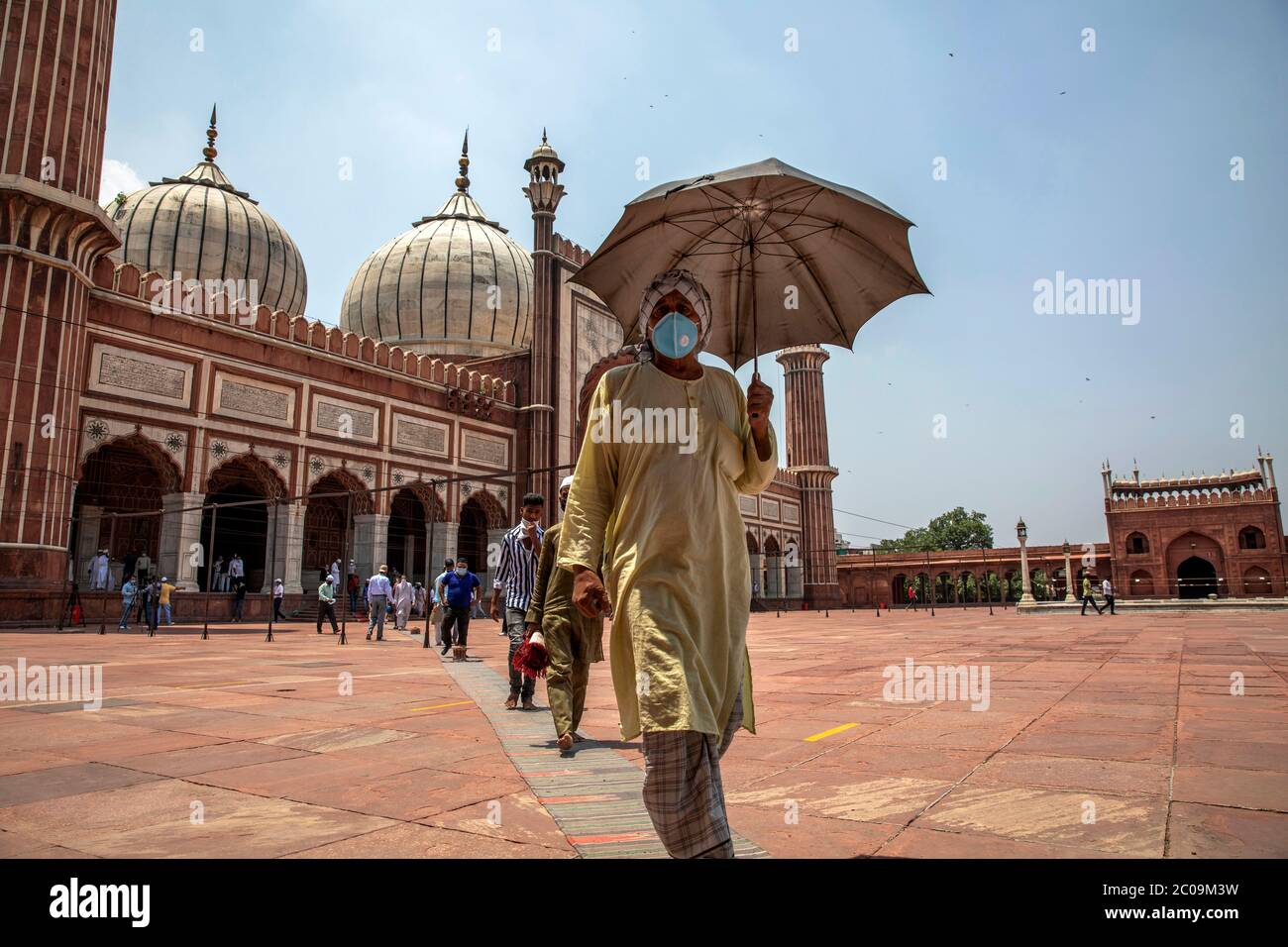 Muslims walk outside after prayers at Jama Masjid after the opening of most of the religious places as India eases lockdown restrictions that were imp Stock Photo