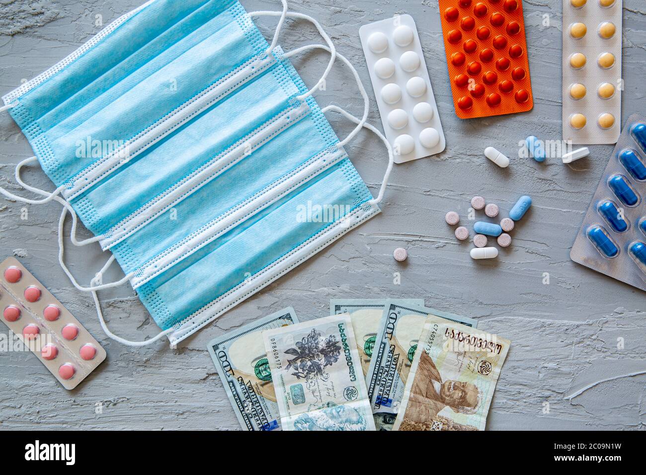 Medical and health costs during coronavirus crisis. Epidemic covid-19 concept in Georgia. Georgian lari banknotes and pills. Stock Photo