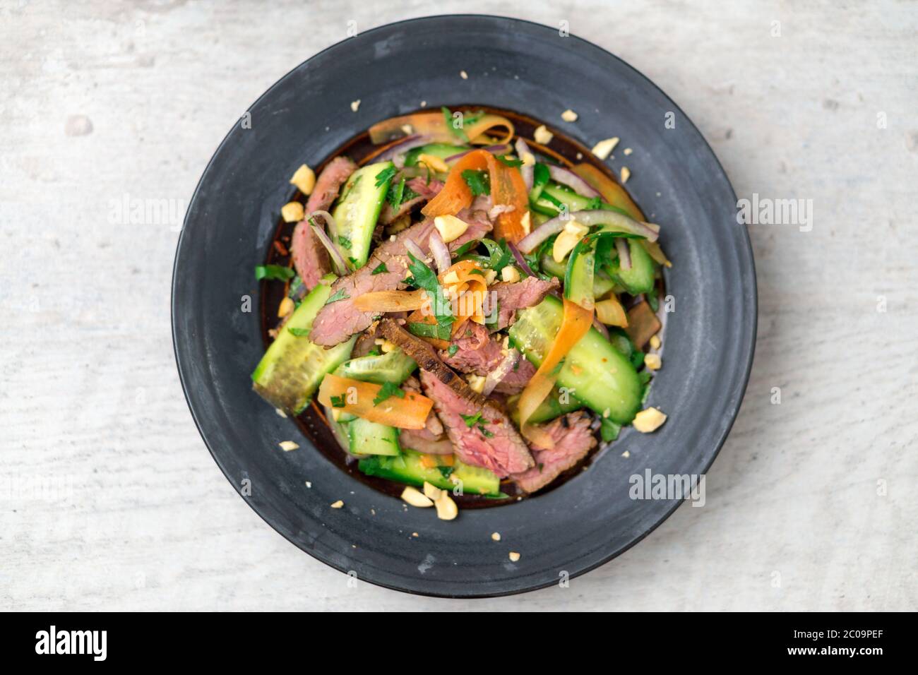 Flat top view of 2 plates of asian beef salad. Inspired by Thai & Vietnamese cuisine, this salad is made with fresh healthy vegetables. Stock Photo