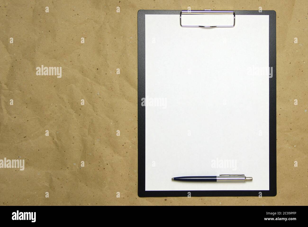 A tablet with a white sheet of A4 format with pen on a beige craft paper.  Concept of analysis, study, attentive work. Stock photo with empty place  for your text and design