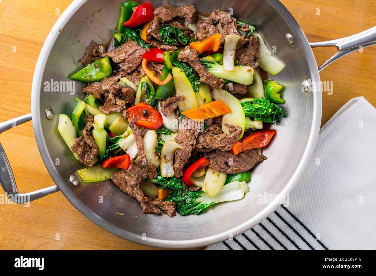 Healthy vegetable & beef stir-fry. Made with flank steak, peppers, onions and bok choy stir fried in an asian wok. Stock Photo
