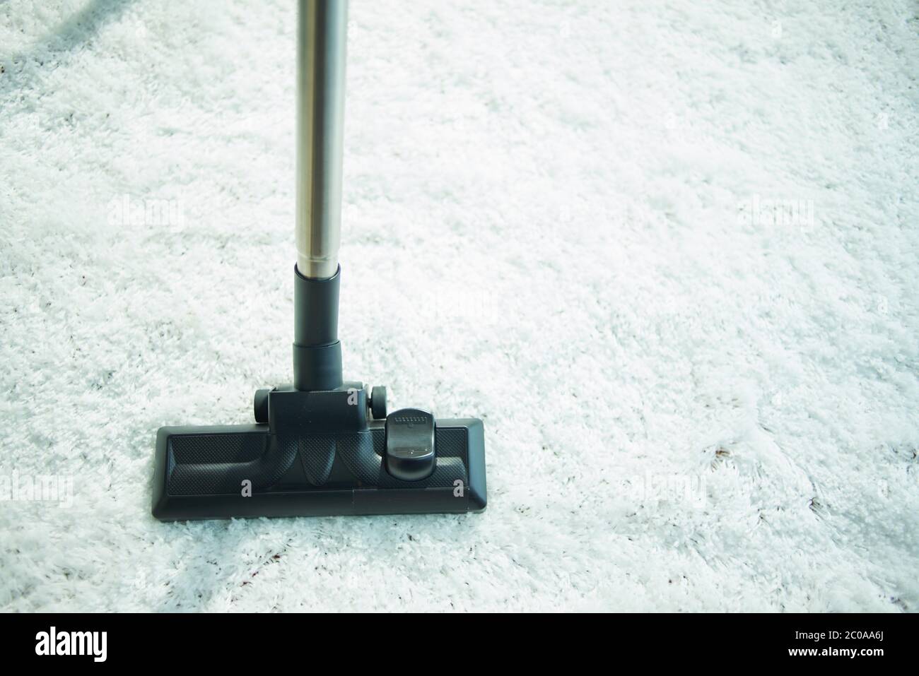 Closeup on vacuum cleaner vacuuming white fluffy carpet Stock Photo Alamy