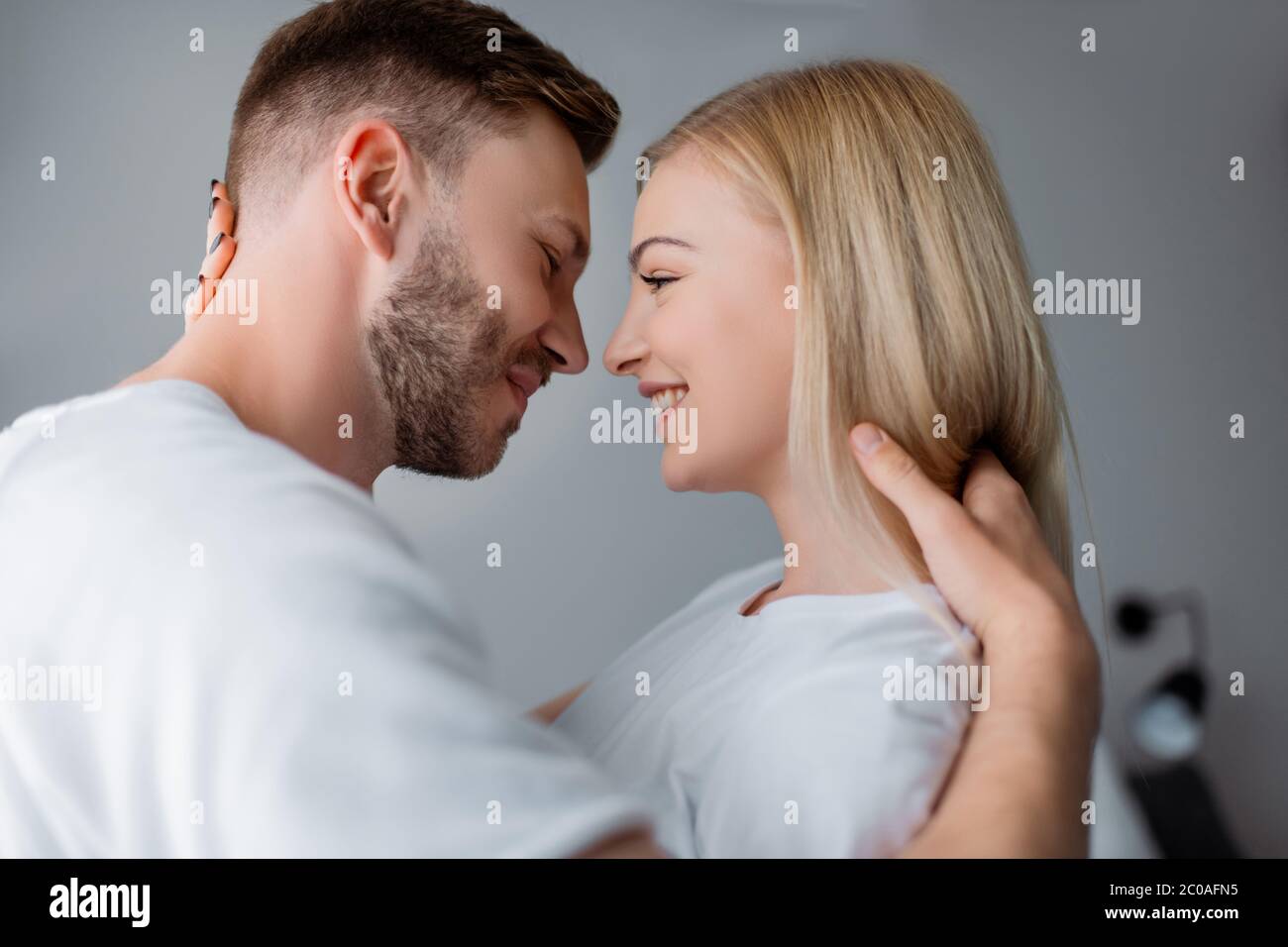 side view of cheerful couple smiling while looking at each other Stock ...
