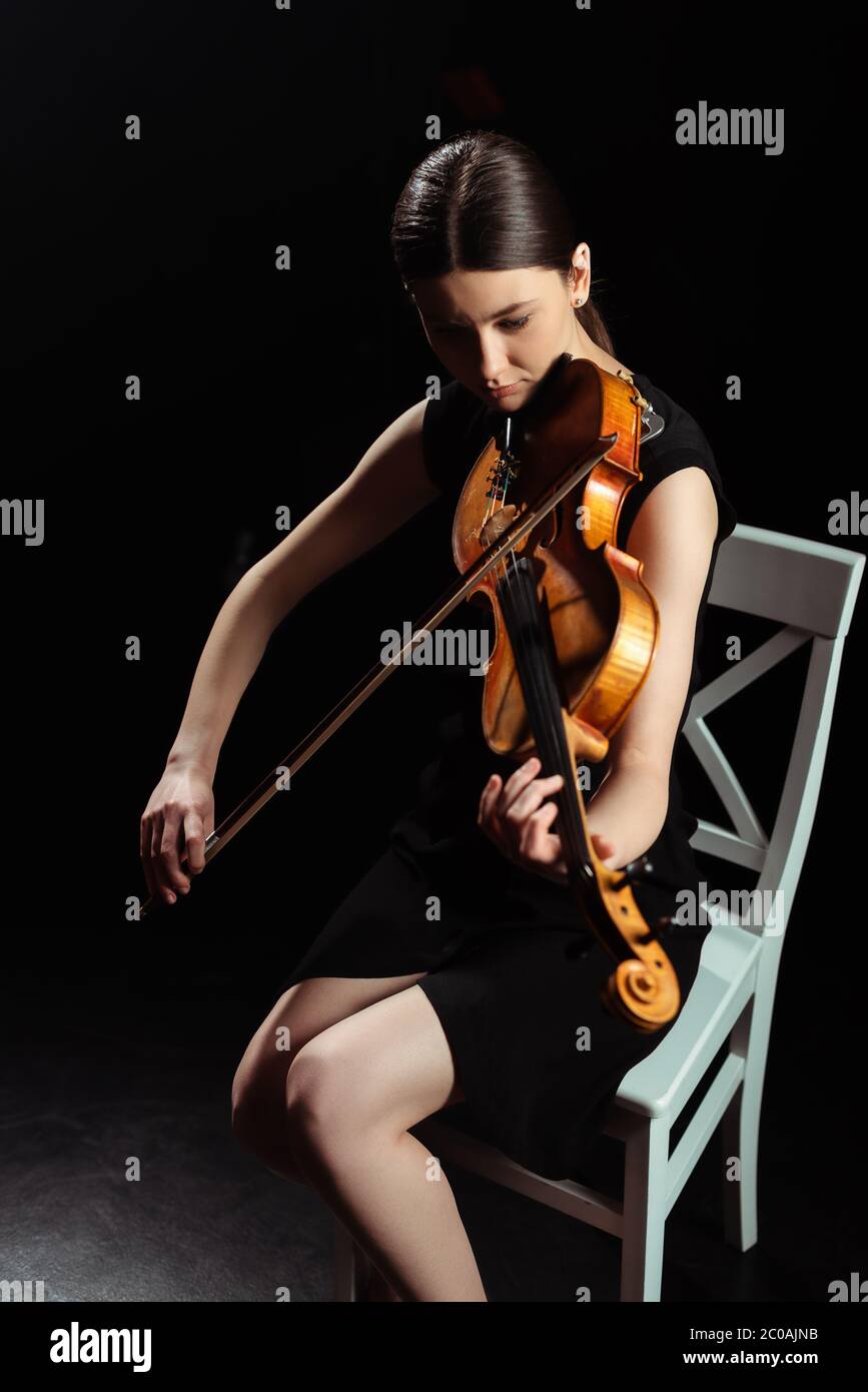 beautiful female musician playing on violin on dark stage Stock Photo ...
