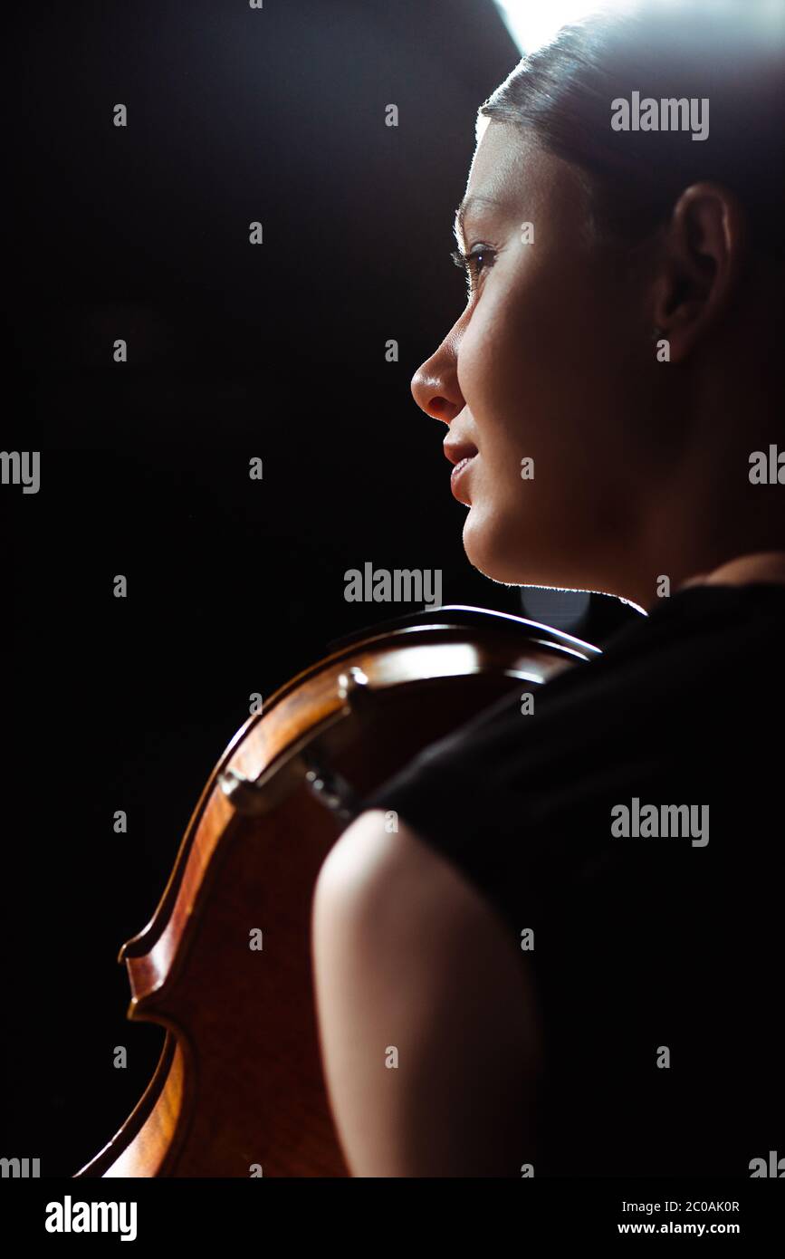beautiful female musician playing on violin on dark stage Stock Photo ...