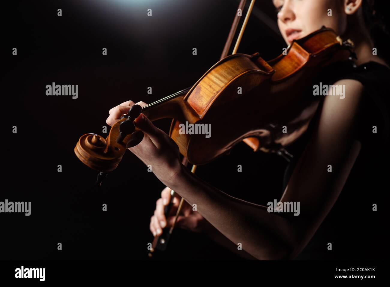 attractive female musician playing on violin on dark stage Stock Photo ...