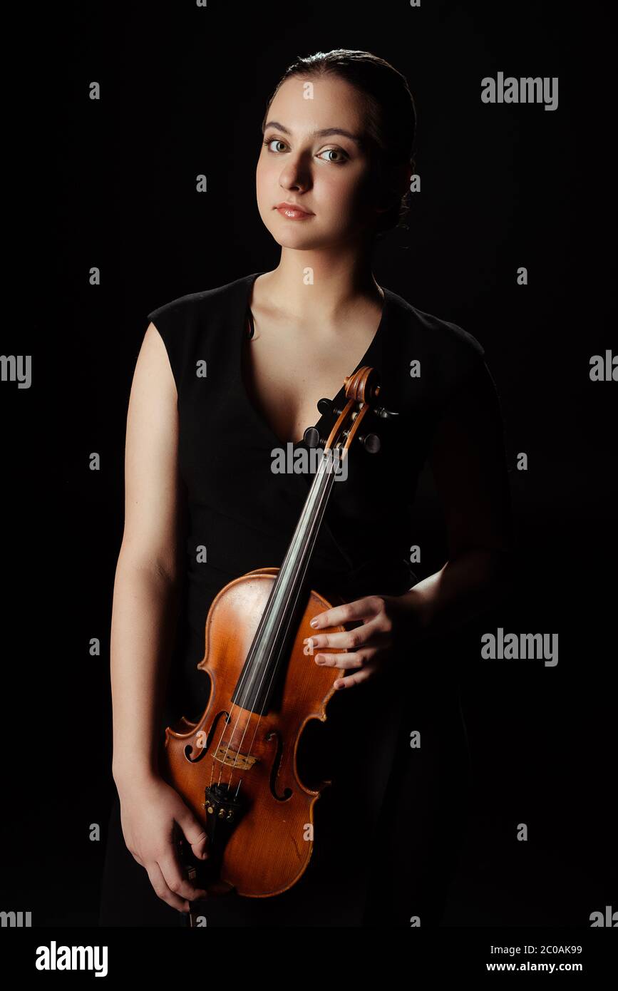 attractive professional musician holding violin isolated on black Stock ...