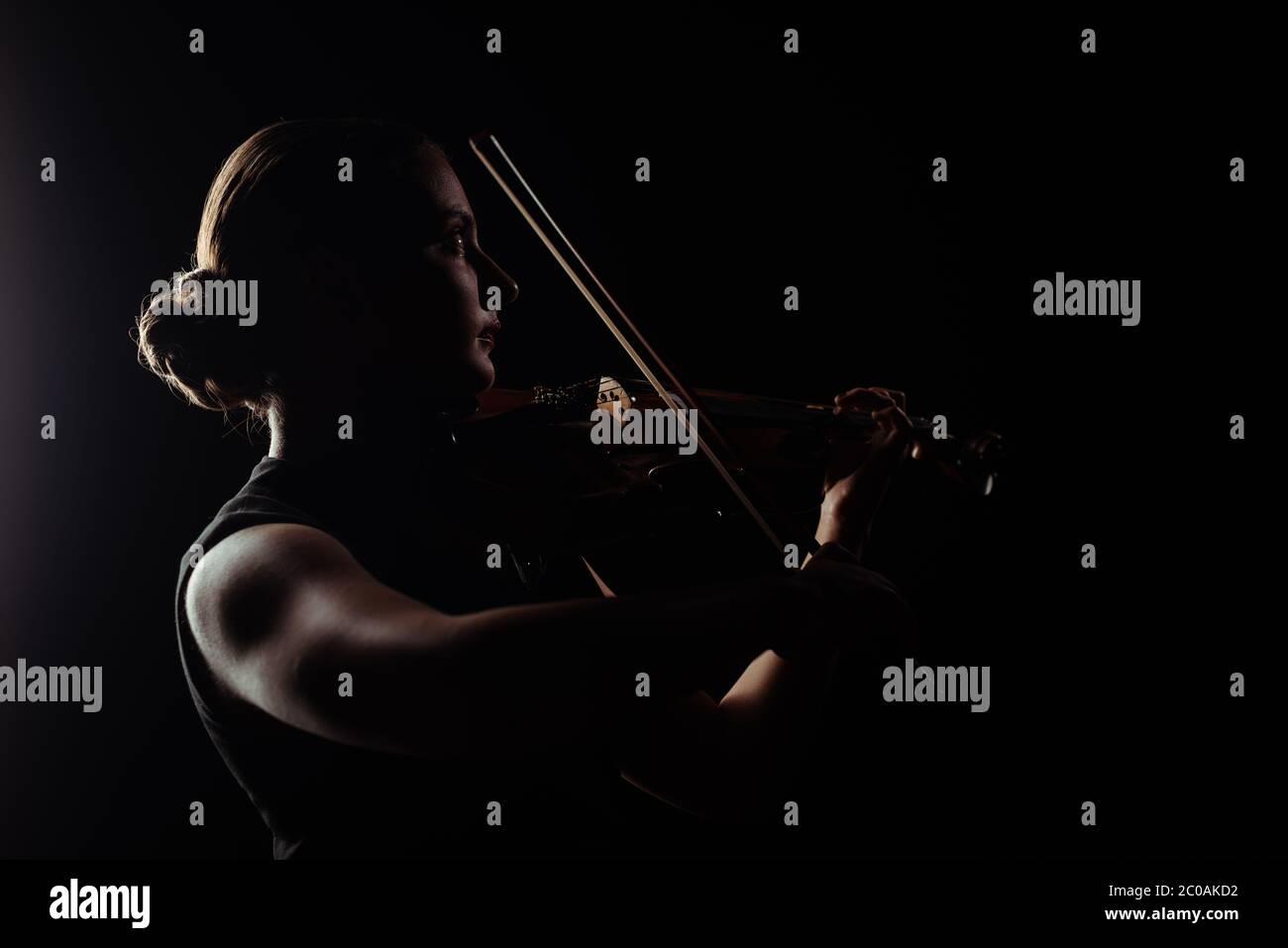 silhouette of female musician playing on violin on dark stage Stock ...