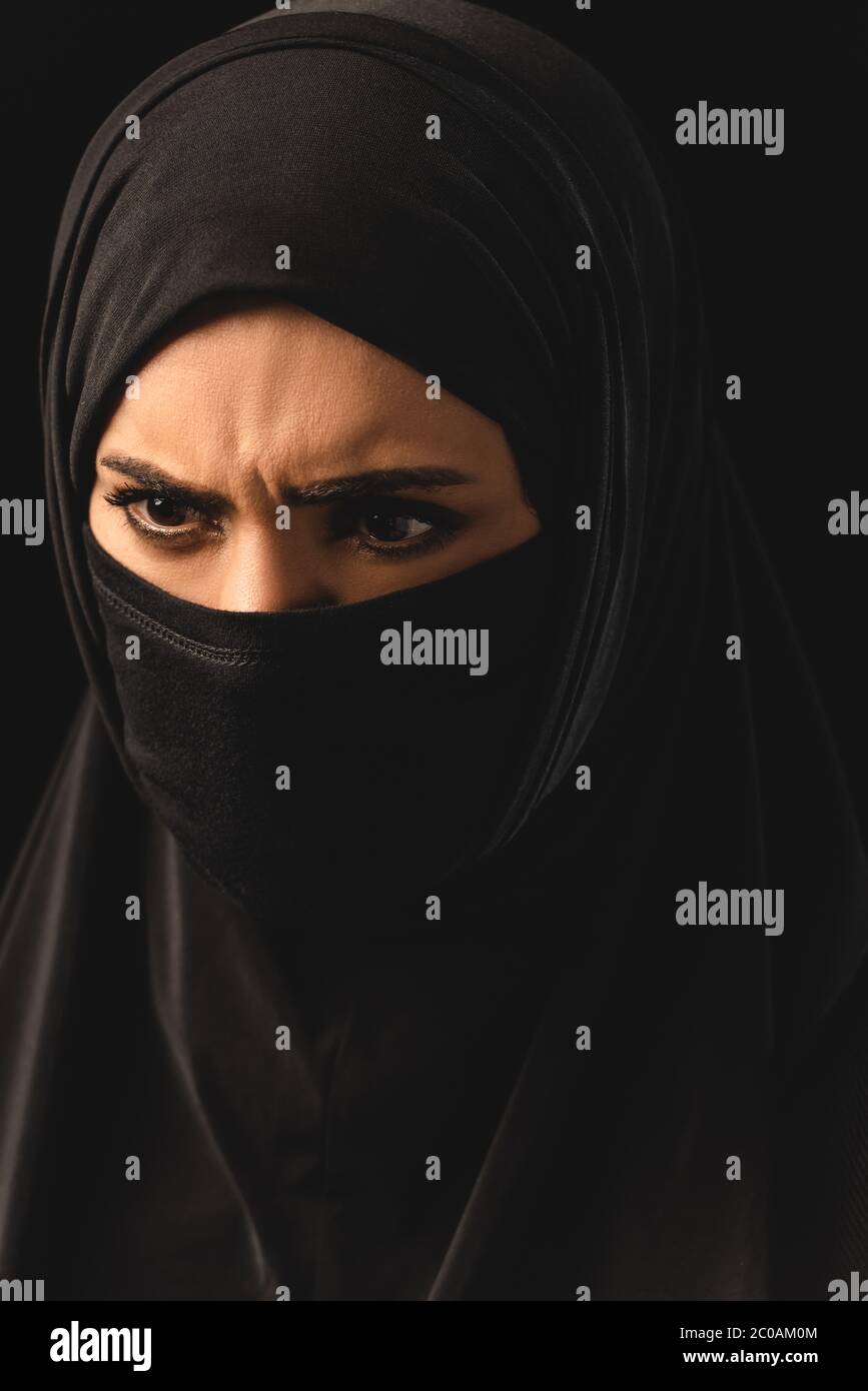 Portrait of aggressive muslim woman in hijab isolated on black Stock ...