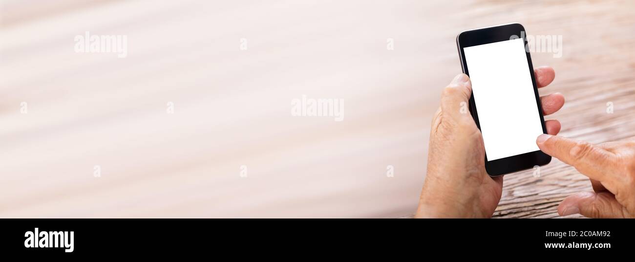 Senior Man Holding Mobile Phone With Empty Screen Stock Photo