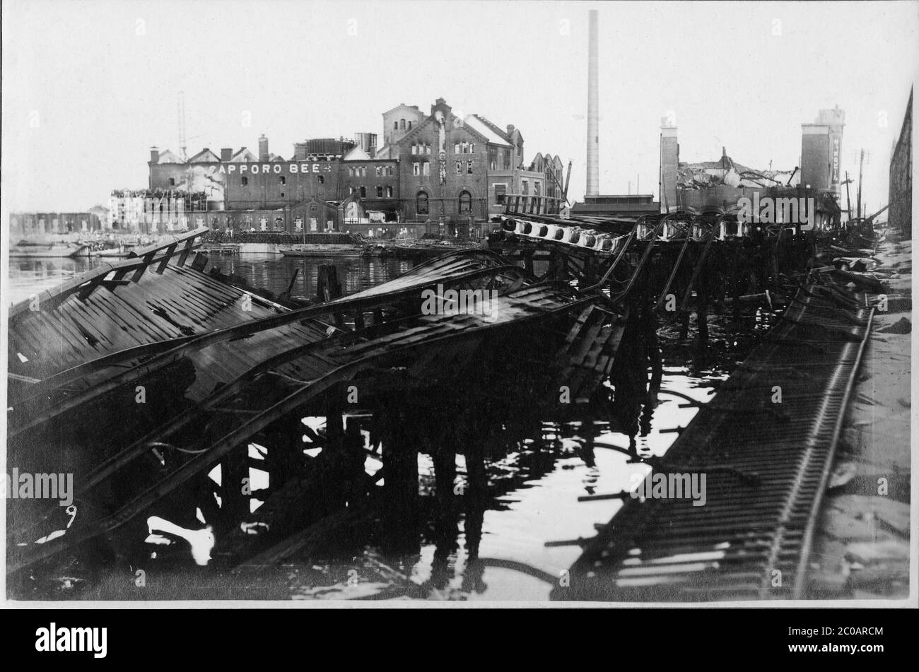 [ 1920s Japan - Great Kanto Earthquake ] — The ruins of Tokyo’s Azumabashi Bridge destroyed by the Great Kanto Earthquake (Kanto Daishinsai) of September 1, 1923 (Taisho 12).  In the back the burned out Sapporo Beer Breweries can be seen.  The quake, with an estimated magnitude between 7.9 and 8.4 on the Richter scale, devastated Tokyo, the port city of Yokohama, surrounding prefectures of Chiba, Kanagawa, and Shizuoka, and claimed over 140,000 victims.  20th century vintage gelatin silver print. Stock Photo