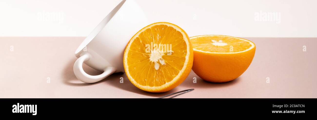 fruit composition with cut orange, cup isolated on beige, panoramic crop Stock Photo