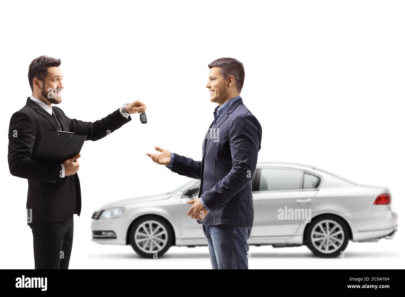 Car salesman giving car keys from a silver new car to a man isolated on white background Stock Photo