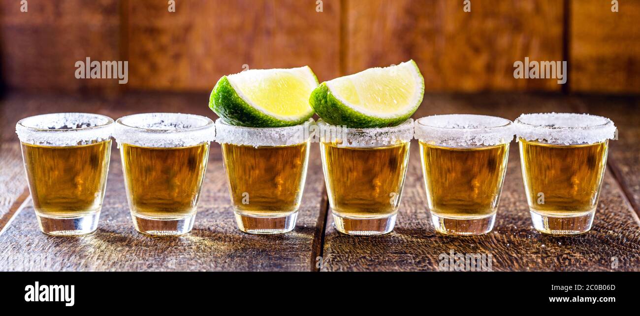 tequila glasses lined up, with tequila, lemon and salt. typical drink