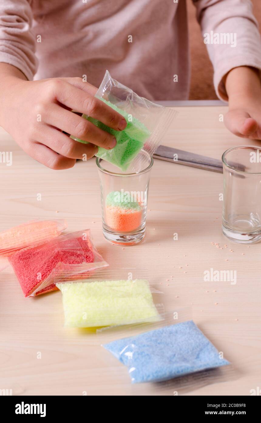 Making candles by yourself . Little girl making candle in the glass
