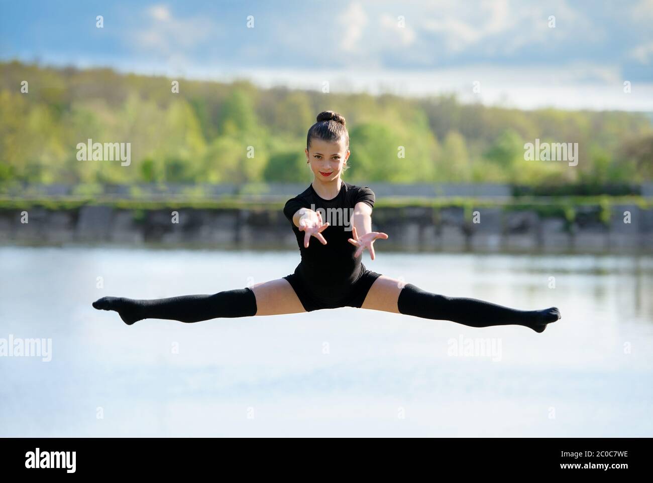 Young Gymnast is Up in the Air Doing Leg-Split Stock Photo