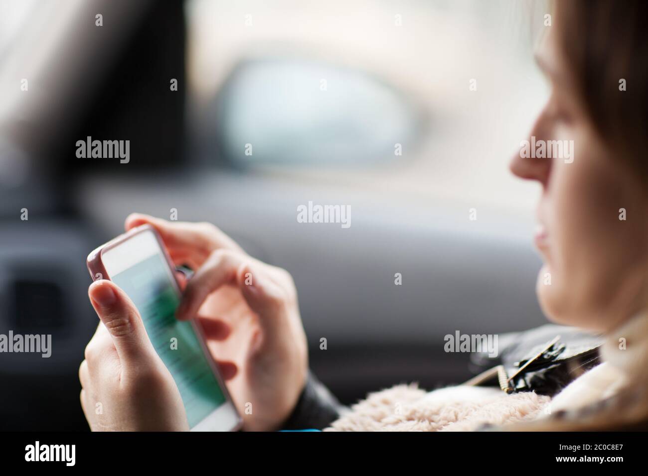 Woman uses smartphone in the car Stock Photo Alamy