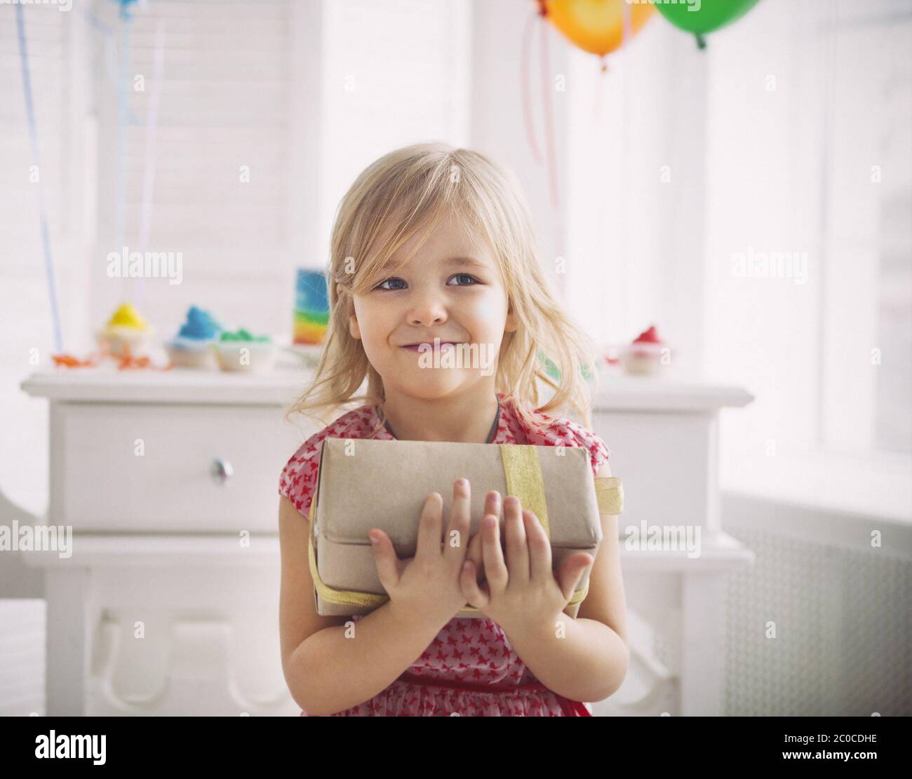 Happy little girl with present celebrating her birthday Stock Photo - Alamy