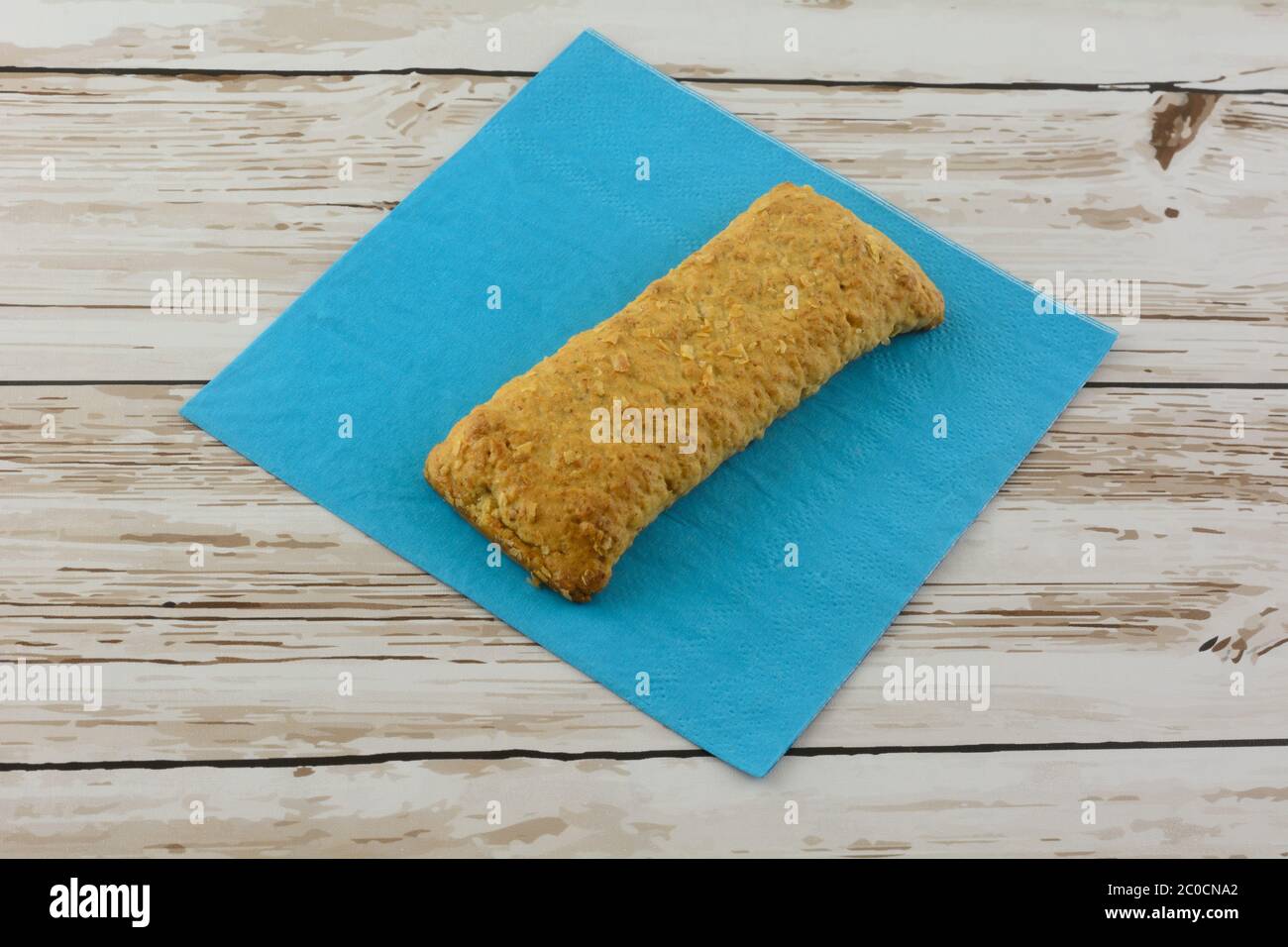 Ready-to-eat soft baked breakfast bar on blue napkin on table Stock Photo