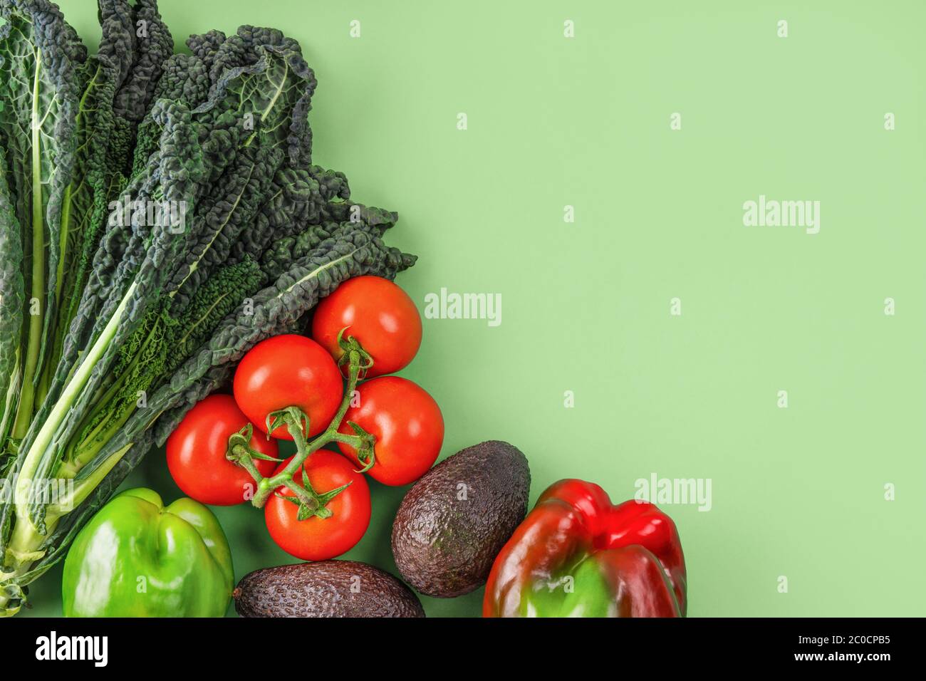 Vegetable creative layout on green background. Flat lay, copy space Stock Photo