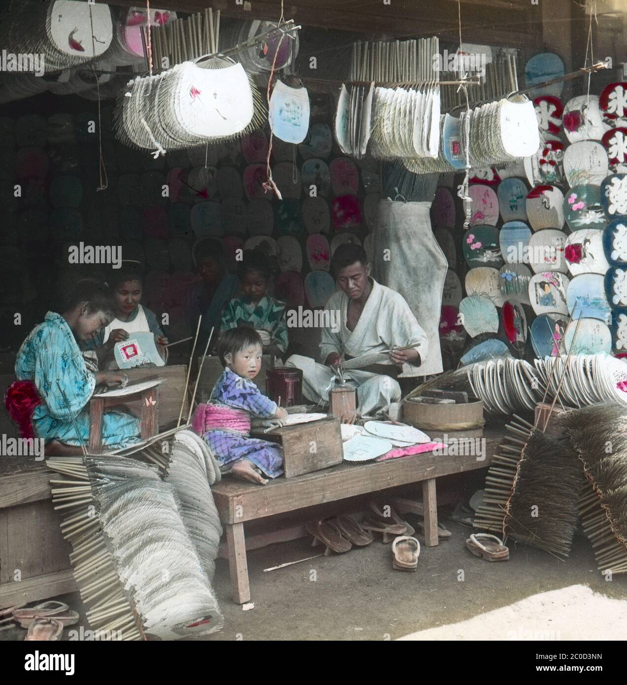 [ 1900s Japan - Japanese Fan Makers ] — A family making Uchiwa fans at the front of their shop.  20th century vintage glass slide. Stock Photo