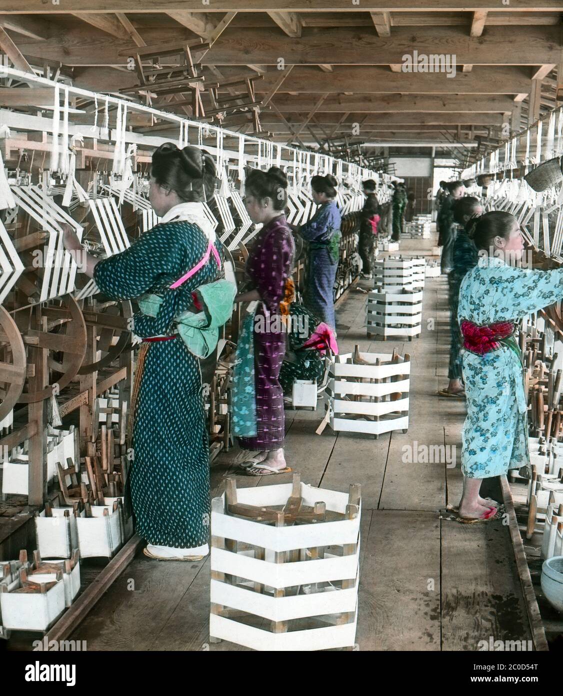 [ 1900s Japan - Japanese Women and Girls Reeling Silk ] — Japanese women and girls reeling silk at a silk factory in Maebashi (前橋市), Gunma Prefecture.  20th century vintage glass slide. Stock Photo
