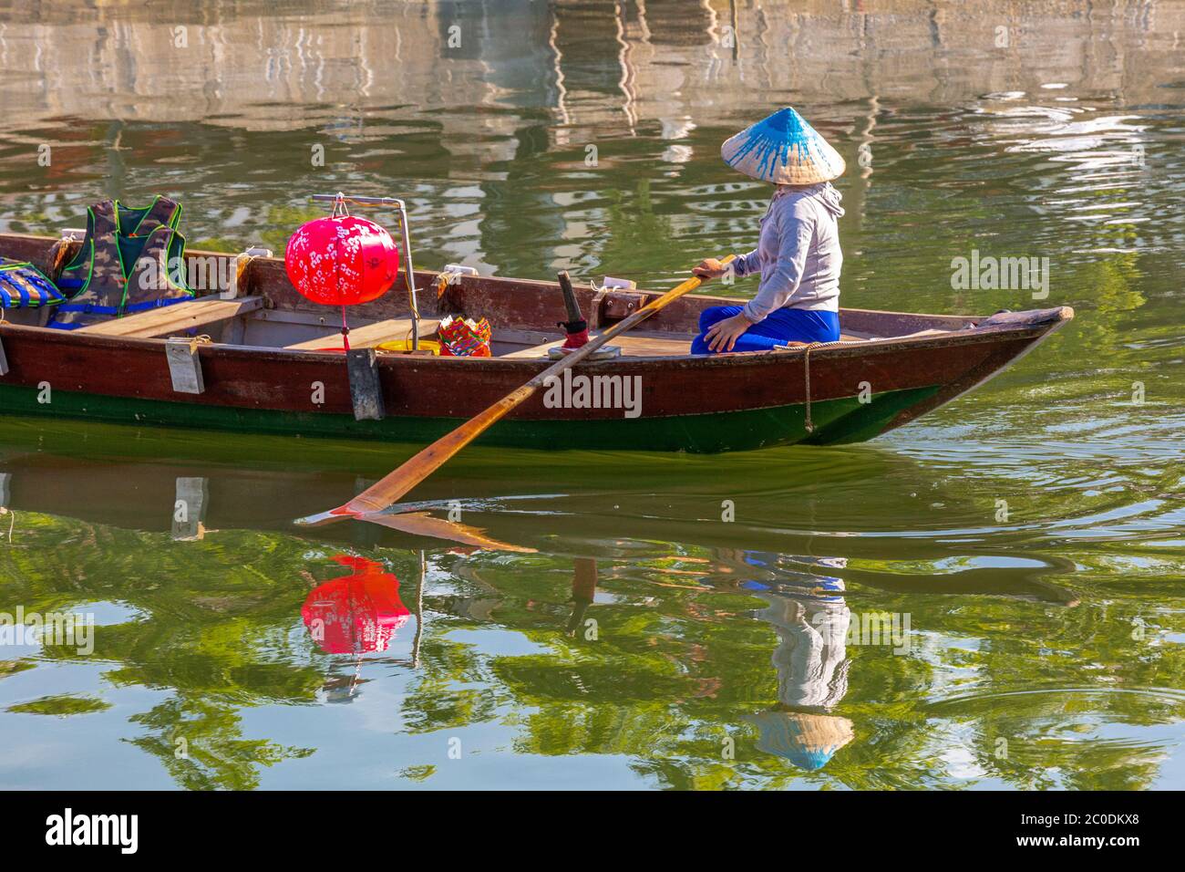 Locals rowing a boat on the Thu Bon river in Hoi An historical town, a UNESCO world heritage. Stock Photo